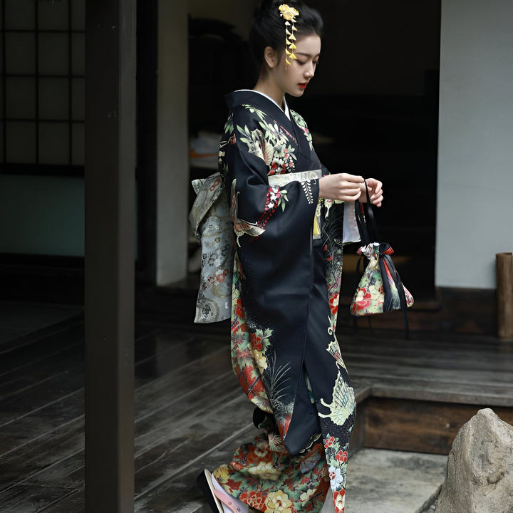 Femme élégante en kimono noir fleuri avec obi assorti. Kimono traditionnel japonais de haute qualité à motifs floraux et grues. Découvrez notre collection de kimonos uniques.