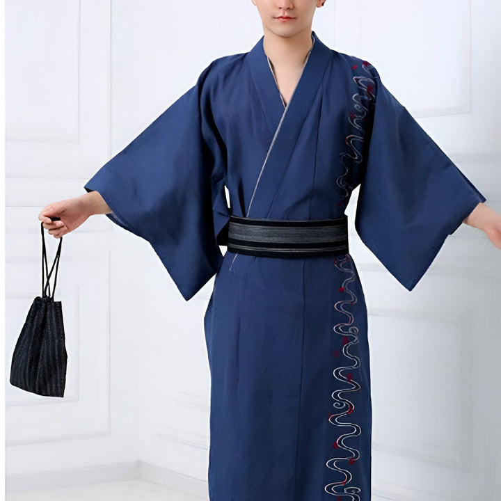 Homme portant un kimono japonais bleu avec une ceinture obi noire et grise, tenant un sac assorti. Vente de kimonos pour hommes.