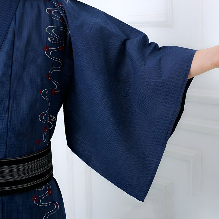 Détail d'un kimono bleu avec motifs brodés et obi noir. Vêtements traditionnels japonais à vendre.