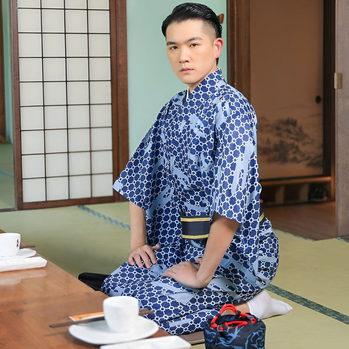 Homme asiatique portant un kimono traditionnel bleu à motifs dans un intérieur japonais typique. Kimono pour homme disponible à l'achat.