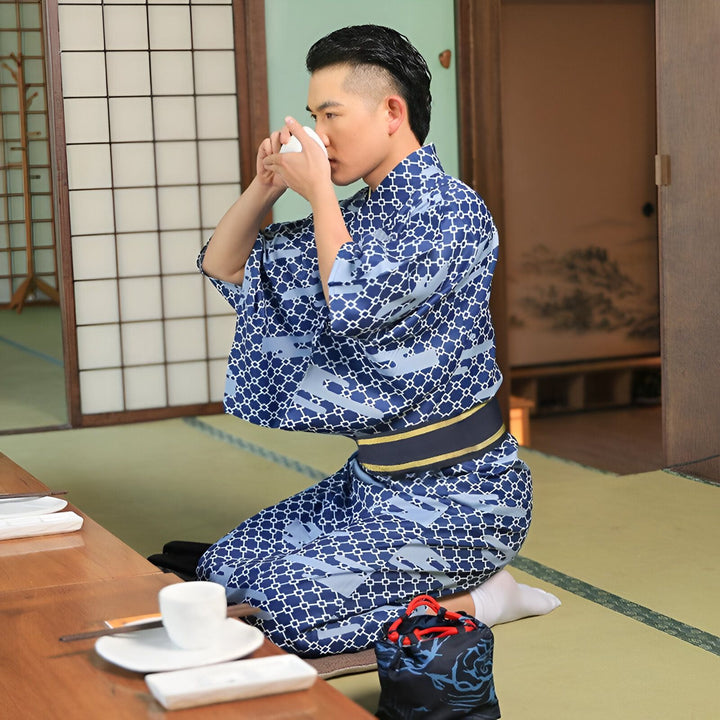 Homme en kimono bleu à motifs buvant du thé dans un intérieur japonais traditionnel. Kimono pour hommes disponible à l'achat.