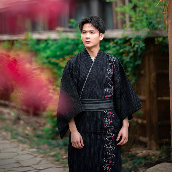 Homme portant un kimono japonais traditionnel noir à rayures. Vêtements japonais, yukata, mode asiatique. Découvrez notre collection de kimonos pour hommes.