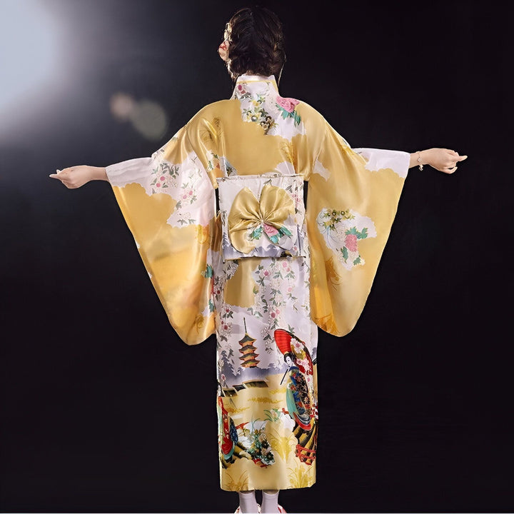 Dos d'une femme portant un kimono japonais jaune et blanc à motifs floraux et paysages traditionnels. Obi orné d'un grand nœud. Vente de kimonos.