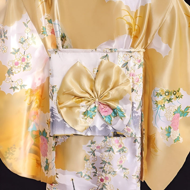 Détail d'un kimono jaune et blanc à motifs floraux avec un obi doré. Kimono traditionnel japonais disponible à l'achat.