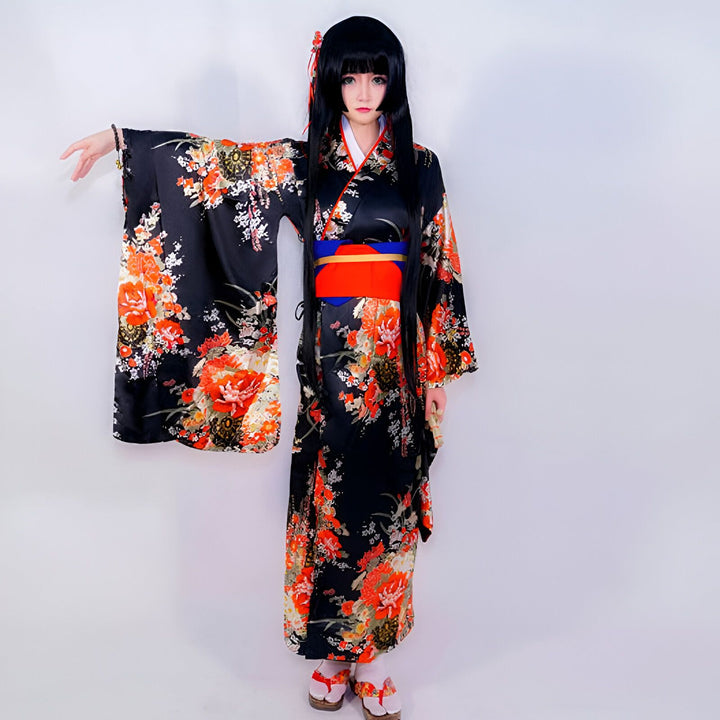 Femme portant un kimono noir à motifs floraux oranges et blancs, avec une ceinture obi rouge et bleue. Vente de kimonos traditionnels et modernes. Découvrez notre collection de kimonos pour femmes.
