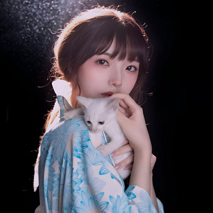 Jeune femme portant un kimono bleu à motifs floraux, tenant un chaton blanc. Vêtements traditionnels japonais. Boutique en ligne de kimonos.