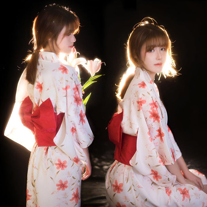 Deux jeunes femmes en kimono fleuri blanc et rouge. Gros plan sur le nœud rouge à l'arrière. Mode japonaise traditionnelle. Vente de kimonos en ligne.