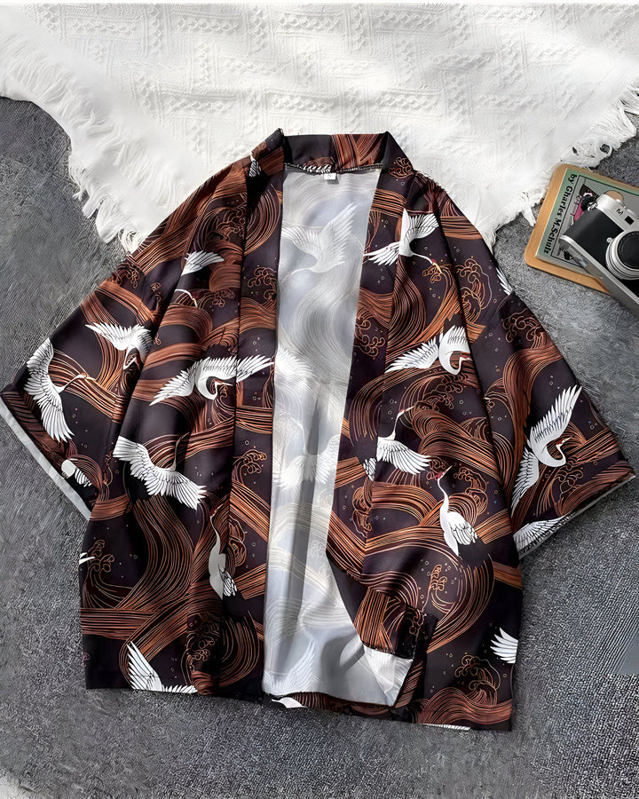 Kimono marron avec motif de grues blanches et vagues stylisées. Vêtement traditionnel japonais revisité, idéal pour un look unique et tendance. Notre collection de kimonos vous offre style et confort.