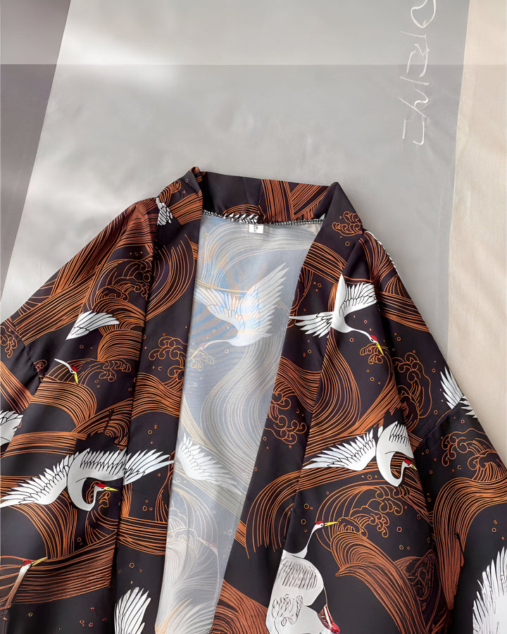 Kimono noir avec motifs de grues blanches et d'vagues ocre. Vêtement traditionnel japonais idéal pour un style unique et élégant. Découvrez notre collection de kimonos.