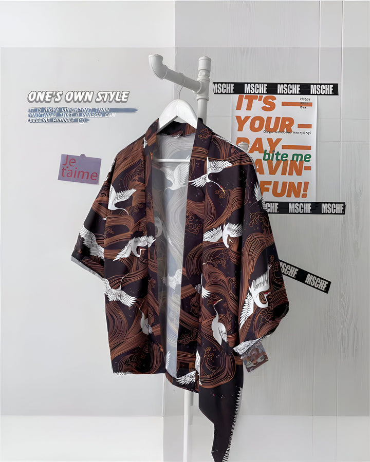 Kimono marron foncé avec motifs de grues blanches suspendu à un portant. Vêtements japonais traditionnels et élégants à la vente. Parfait pour un look unique et tendance. Découvrez notre collection de kimonos !