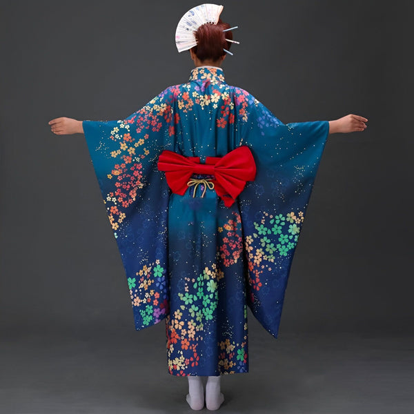 Vue arrière d'une personne portant un kimono bleu fleuri avec un obi rouge, tenant un éventail. Kimono traditionnel japonais à vendre.