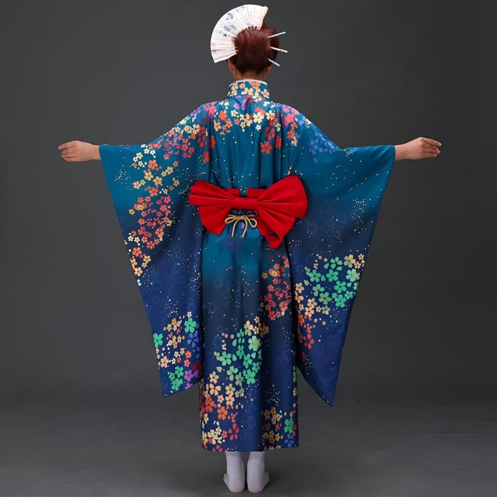 Vue arrière d'une personne portant un kimono bleu fleuri avec un obi rouge, tenant un éventail. Kimono traditionnel japonais à vendre.
