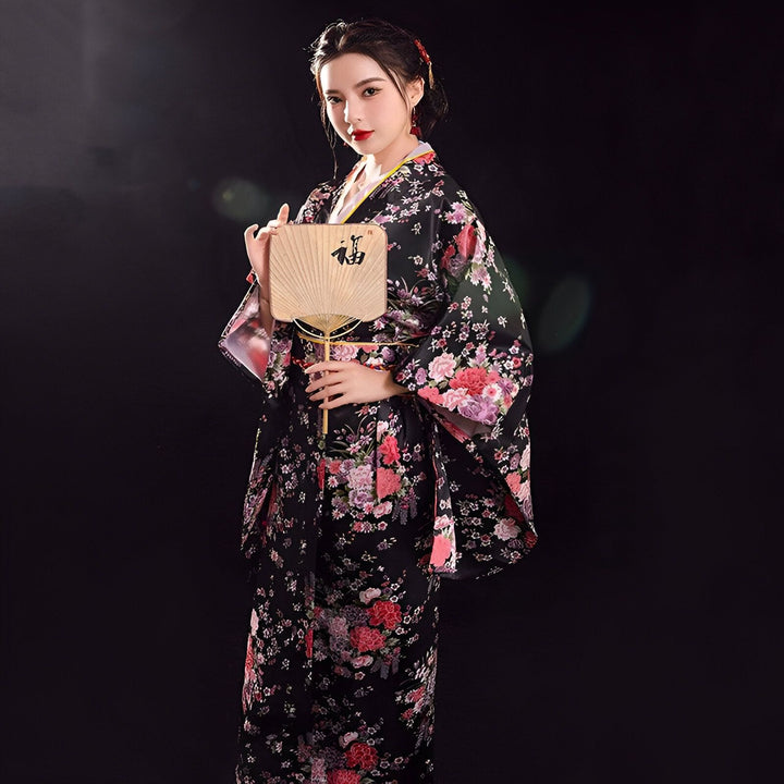 Femme en kimono fleuri noir avec éventail. Découvrez notre collection de kimonos japonais authentiques. Parfait pour un look traditionnel et élégant. Kimonos de qualité supérieure pour toutes les occasions.
