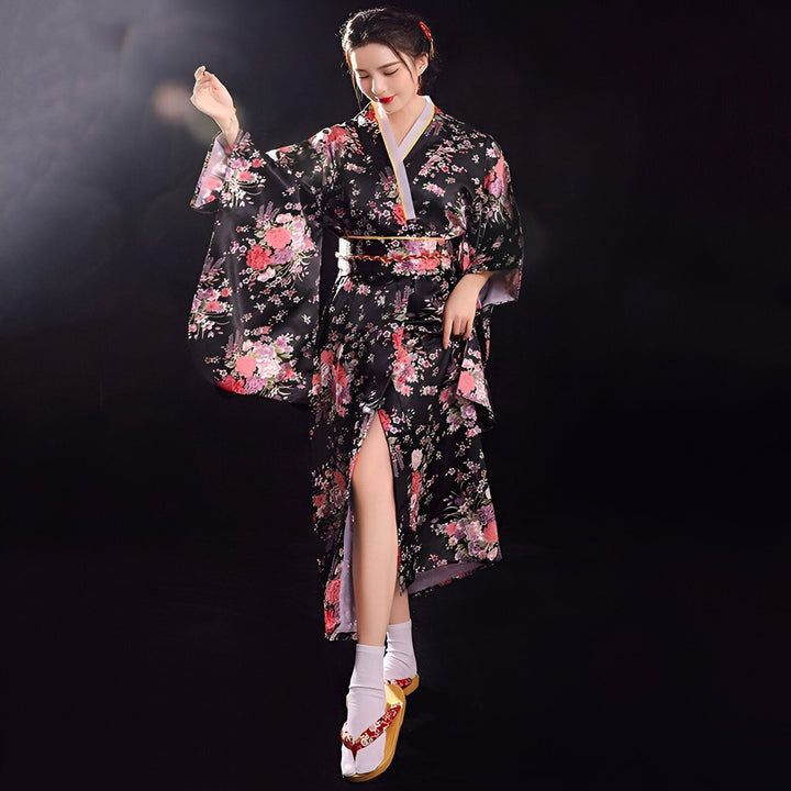 Femme portant un kimono noir fleuri. Kimono traditionnel japonais avec motifs floraux, disponible à l'achat. Découvrez notre collection de kimonos uniques.