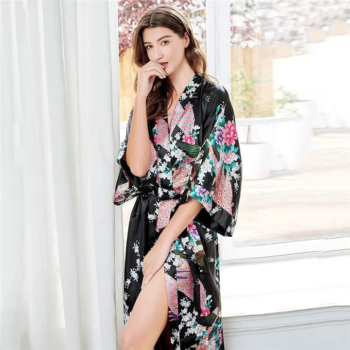 Femme portant un kimono noir à motifs floraux et de plumes de paon. Vente de kimonos pour femmes, confortables et élégants.