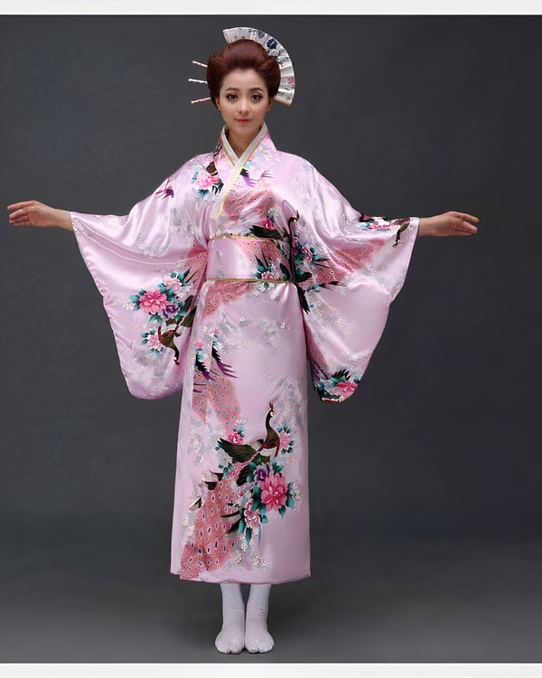 Femme portant un kimono rose avec des motifs de paons et de fleurs. Kimonos traditionnels japonais à vendre.