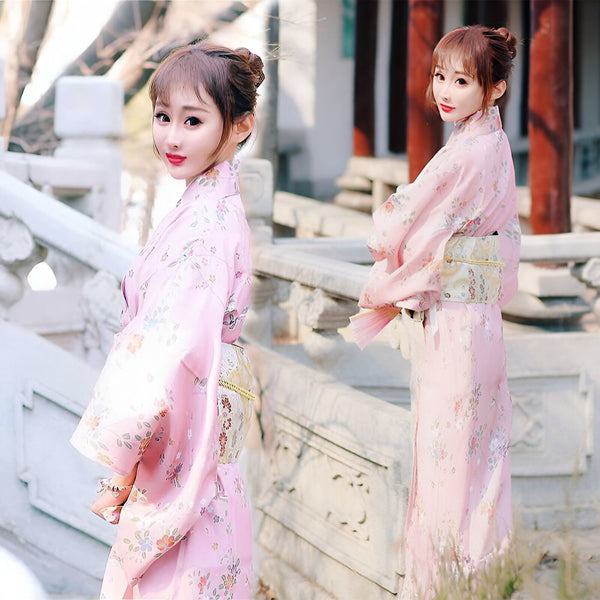 Deux femmes portant des kimonos roses à motifs floraux. Découvrez notre collection de kimonos traditionnels et modernes.