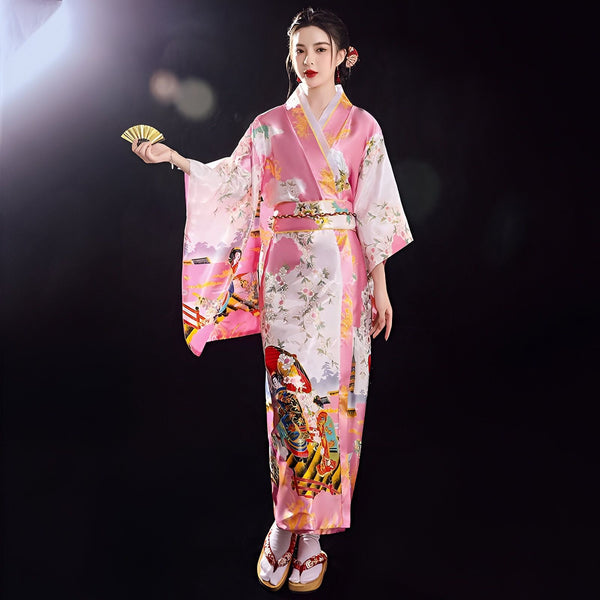 Femme portant un kimono rose imprimé avec un éventail, vêtement traditionnel japonais. Kimonos de haute qualité à vendre.