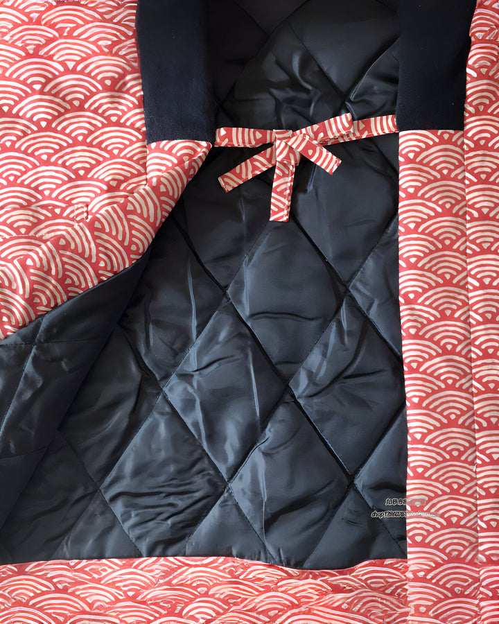 Intérieur d'un kimono matelassé avec motif de vagues rouges et blanches. Détail de la doublure noire et du nœud de fermeture. Kimonos disponibles à l'achat.