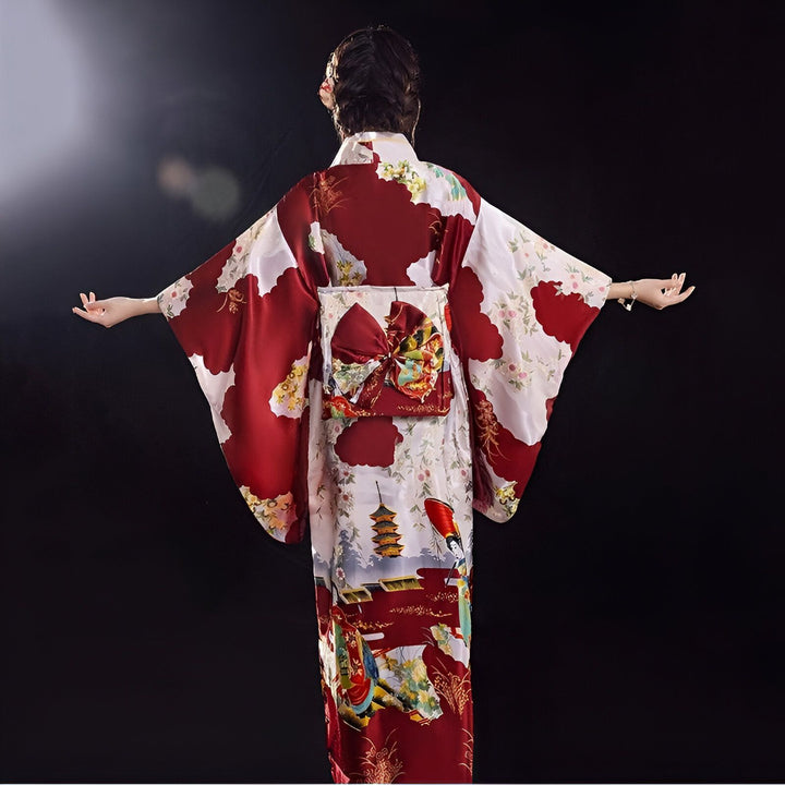 Vue arrière d'une femme portant un kimono rouge et blanc orné de motifs traditionnels japonais. Le kimono présente une large ceinture obi avec un nœud décoratif. Nos kimonos authentiques, pour un style japonais unique.