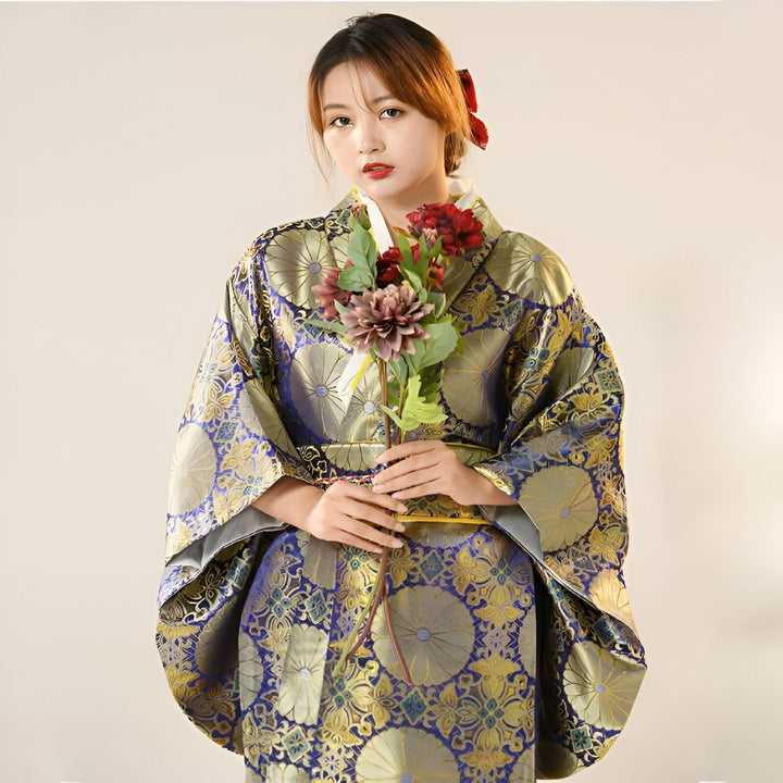 Femme portant un kimono traditionnel bleu et or, tenant des fleurs. Vêtements japonais élégants en vente.