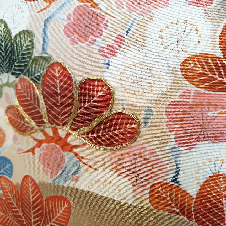 Détail de tissu de kimono japonais avec motif floral et feuilles brodées. Motifs traditionnels, texture raffinée. Parfait pour amateurs de kimonos et culture japonaise.