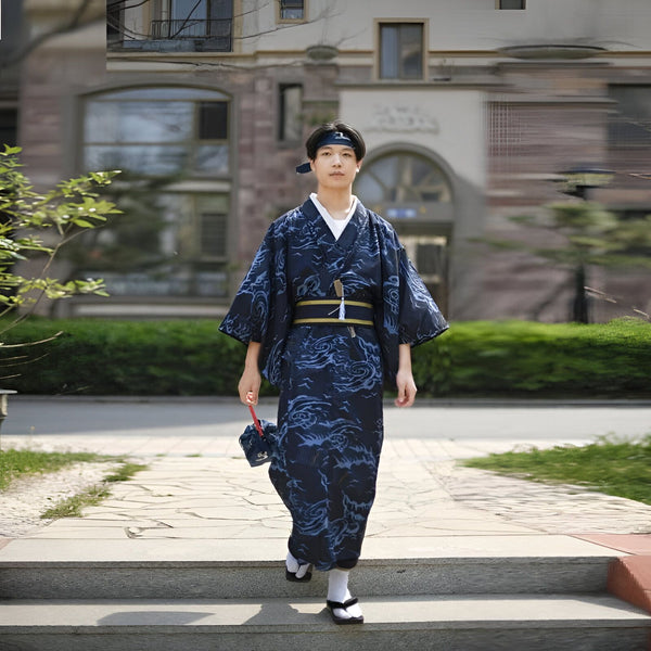 Jeune homme portant un kimono bleu marine à motifs et un bandeau assorti, tenant un sac. Kimonos traditionnels et modernes disponibles à l'achat.