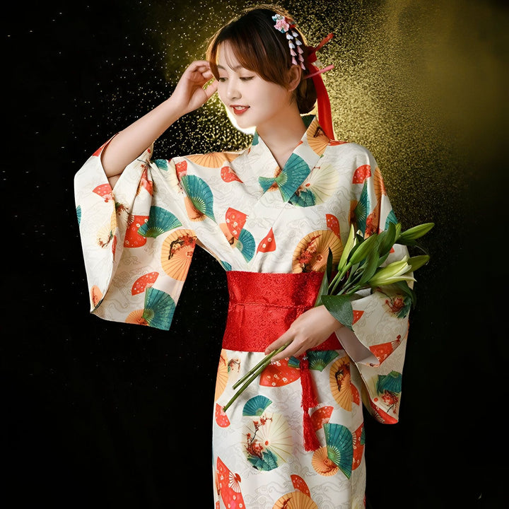 Femme en kimono traditionnel japonais avec motifs d'éventails colorés et ceinture rouge. Vêtements japonais authentiques, style et élégance. Découvrez notre collection de kimonos uniques.