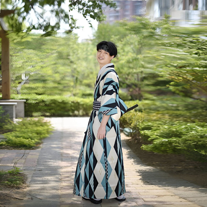 Homme souriant portant un kimono à motifs losanges bleus, noirs et blancs dans un jardin. Vêtements japonais traditionnels, yukata moderne, mode asiatique.