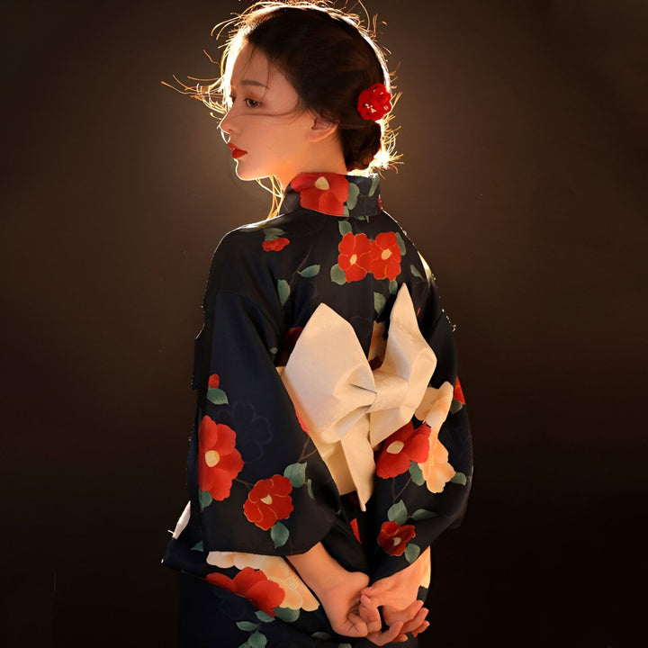 Femme portant un kimono traditionnel japonais à fleurs rouges. Vue de dos, noeud obi blanc. Vêtements traditionnels japonais, style kimono.