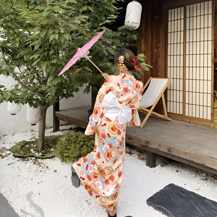 Femme portant un kimono fleuri, tenant une ombrelle rose. Vêtements japonais traditionnels à motifs. Élégance et style japonais. Boutique de kimonos authentiques.
