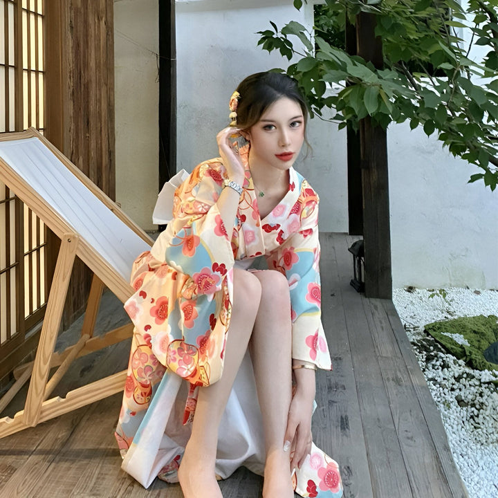 Femme portant un kimono à motifs floraux et ceinture obi, assise sur une chaise longue. Vente de kimonos traditionnels japonais en ligne.