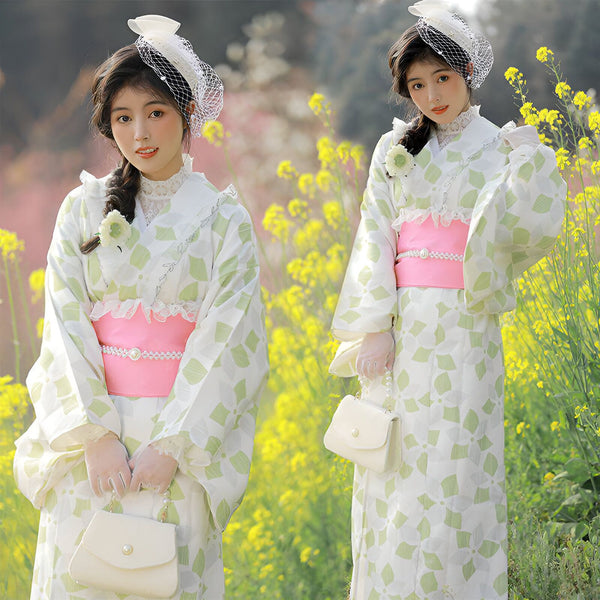Deux femmes portant des kimonos japonais à motifs floraux verts et blancs avec des ceintures roses. Kimonos élégants et traditionnels en vente.