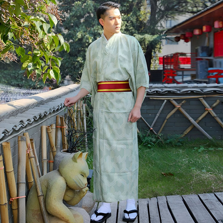 Homme portant un kimono japonais traditionnel vert pâle avec une ceinture rouge et or. Vente de kimonos japonais authentiques pour hommes.