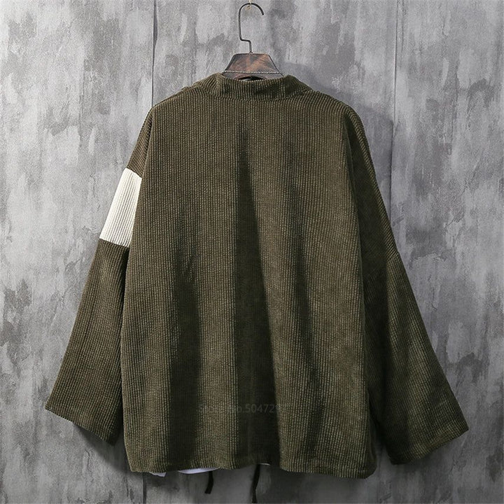 Dos d'un kimono en velours côtelé vert olive sur un cintre. Manches larges, empiècement blanc sur une manche. Vêtement japonais de notre collection.