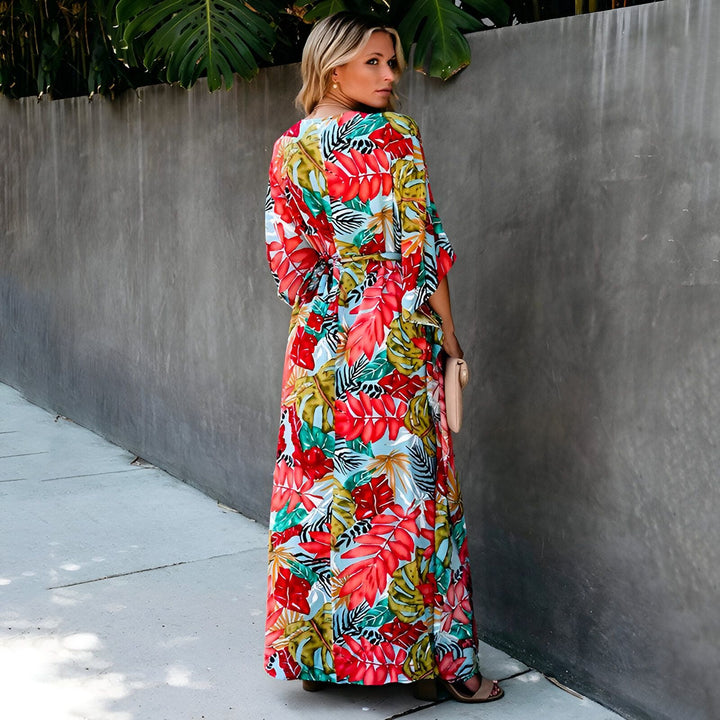 Femme portant un kimono long à imprimé floral coloré. Vente de kimonos pour femmes. Style décontracté et élégant. Motifs de feuilles rouges, vertes et bleues. Mode féminine.