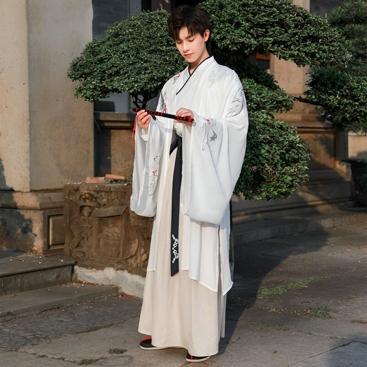 Homme portant un kimono blanc traditionnel avec motifs, tenant une flûte. Vente de kimonos authentiques en ligne. Mode japonaise, vêtements traditionnels.