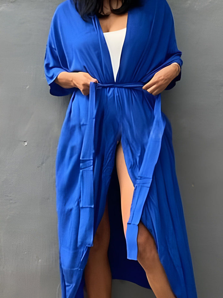 Kimono bleu vibrant porté par une femme, noué à la taille. Vêtement élégant et confortable. Découvrez notre collection de kimonos.
