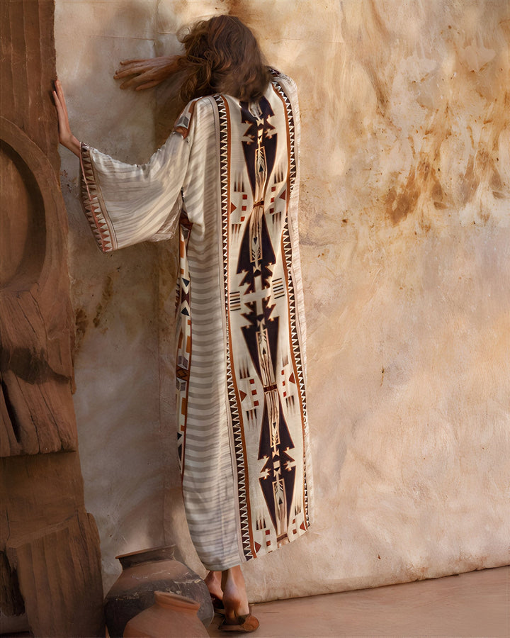 Femme portant un kimono beige à motifs ethniques. Vêtement bohème chic à manches larges. Idéal pour un look décontracté et élégant. Découvrez notre collection de kimonos uniques.