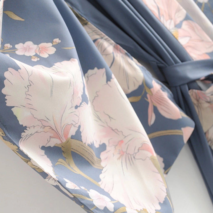 Détail d'un kimono bleu avec motifs floraux roses et blancs. Élégance et confort. Découvrez notre collection de kimonos uniques.