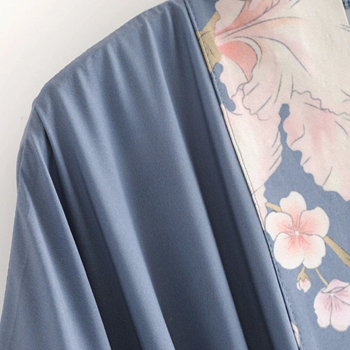 Détail d'un kimono bleu avec motifs floraux roses. Vêtement traditionnel japonais, idéal pour un style unique et élégant. Découvrez notre collection de kimonos.
