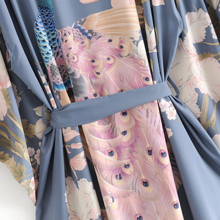 Kimono bleu avec motifs de paon et de fleurs. Détail du tissu avec ceinture. Vêtement de style japonais, idéal pour la maison ou comme tenue d'extérieur élégante.