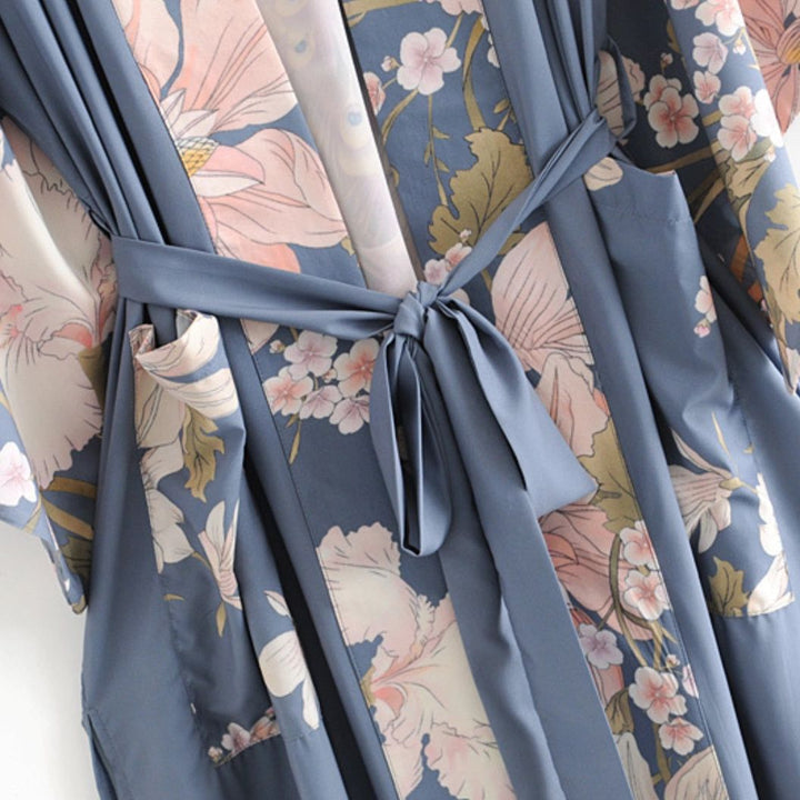 Kimono bleu à motifs floraux, ceinture nouée. Vêtement d'intérieur élégant et confortable. Découvrez notre collection de kimonos en ligne.