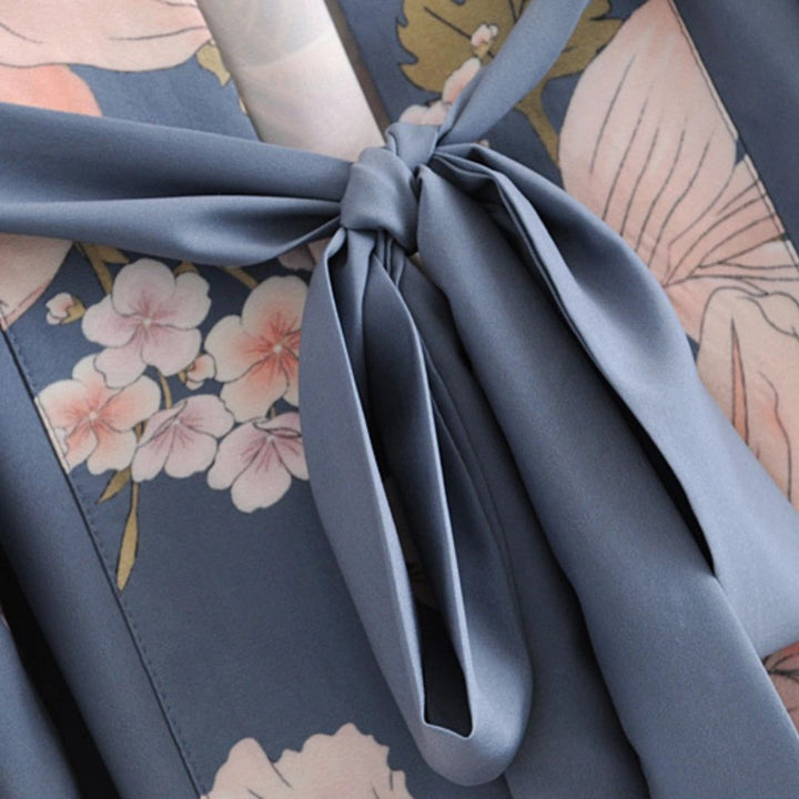 Détail d'un kimono fleuri bleu avec ceinture nouée. Vêtements japonais traditionnels à motifs floraux. Kimonos pour femmes, élégance et style japonais.