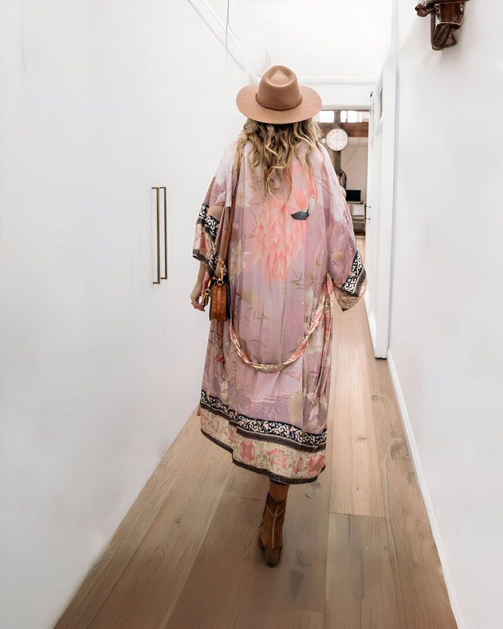 Femme portant un kimono rose fleuri avec chapeau et bottes. Élégance décontractée. Découvrez notre collection de kimonos uniques.