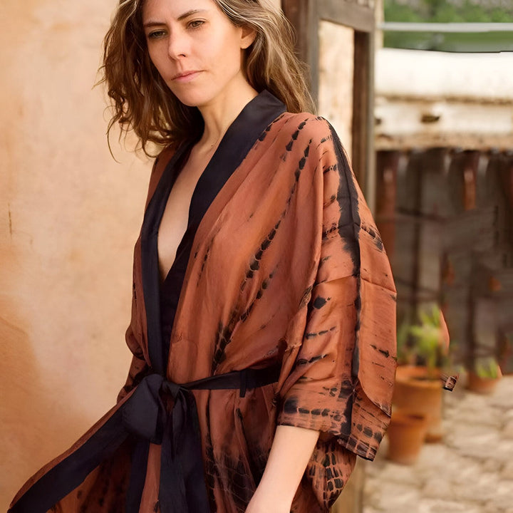 Femme portant un kimono marron à motifs noirs, noué à la taille. Vêtements de détente élégants. Collection de kimonos de notre boutique.