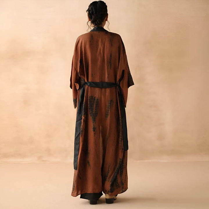 Kimono long marron et noir porté par une femme, vue de dos. Vêtement de style japonais, idéal pour une tenue décontractée ou une occasion spéciale. Découvrez notre collection de kimonos uniques.