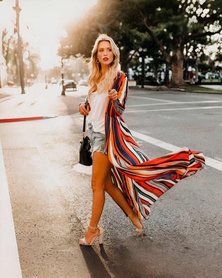 Femme blonde portant un kimono rayé coloré. Vente de kimonos tendance en ligne. Style décontracté chic en kimono. Mode femme, look d'été.