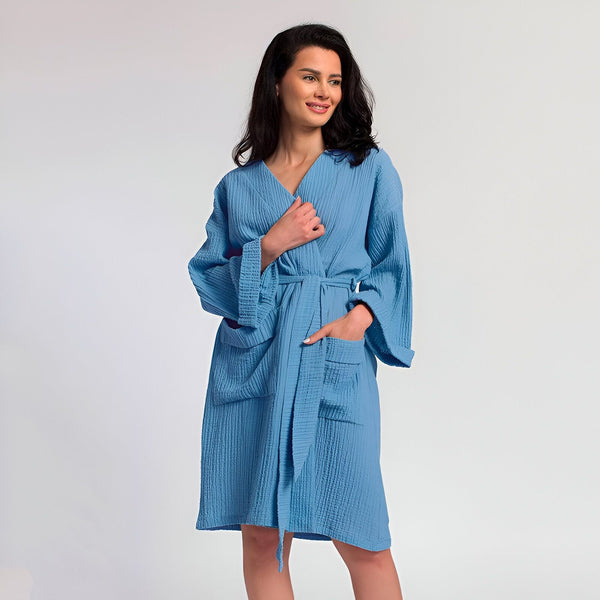 Femme souriante portant un kimono bleu clair avec ceinture. Vente de kimonos confortables et élégants pour femmes.