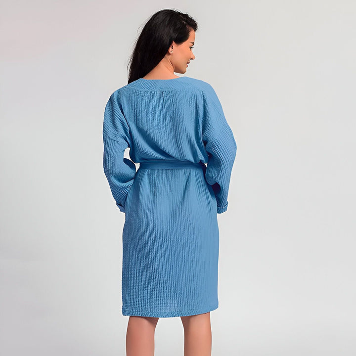 Femme portant un kimono bleu en coton gaufré. Élégant peignoir ou robe de chambre. Vêtements japonais traditionnels revisités. Kimono confortable et léger. Boutique en ligne de kimonos.